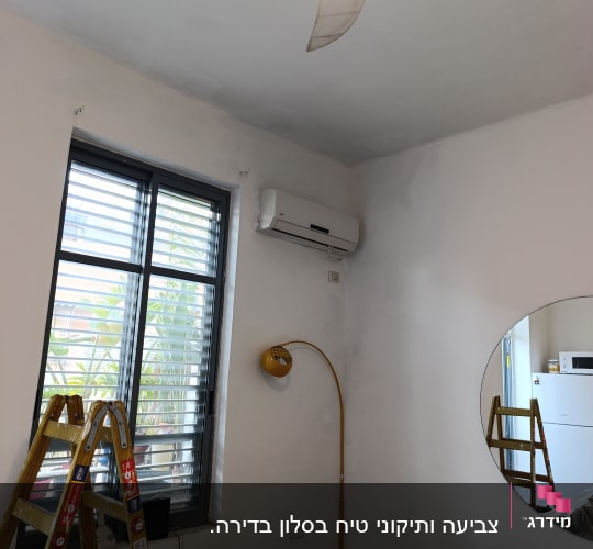 סולם וחדר עם קירות צבועים ומזגן